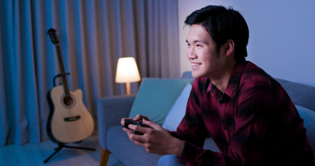 Young Asian Handsome Pro Gamer Feel Excited While playing in Online Cyber Sport Game at homeの写真素材
