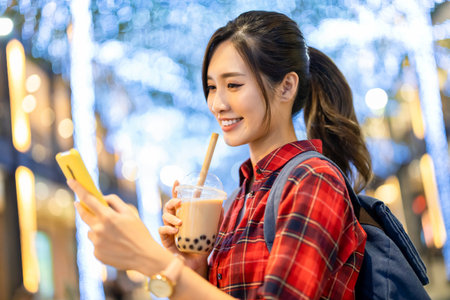 close up of asian woman use smartphone outdoor with face mask while commuting at night