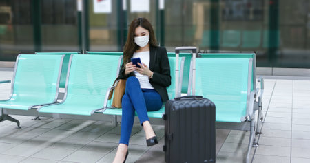asian young businesswoman use smart phone with reusable eco-friendly ecological cup and bag while commuting in cityの写真素材