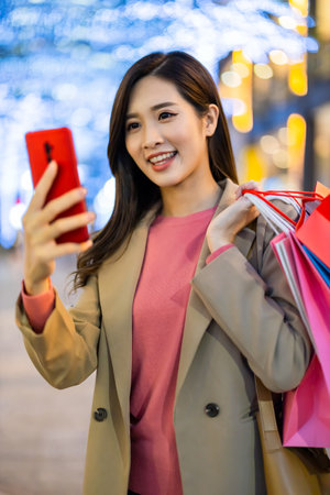 close up of asian woman use smartphone outdoor with face mask while commuting at nightの写真素材
