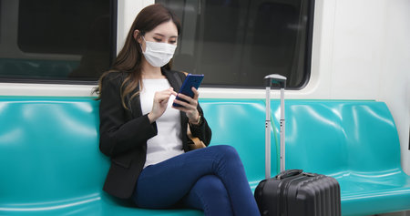 asian young businesswoman use smart phone with reusable eco-friendly ecological cup and bag while commuting in cityの写真素材