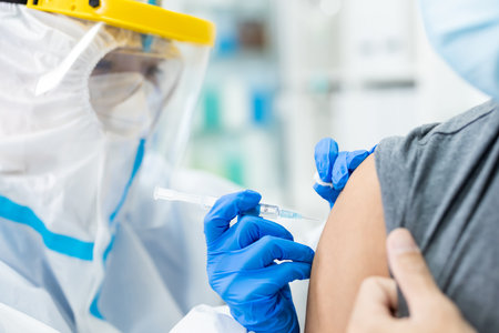 close up of asian doctor giving patient vaccination and injection in hospitalの写真素材