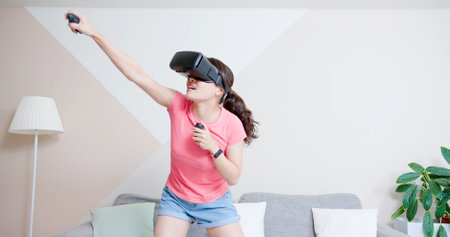 asian woman wears vr glasses and play motion sensing game for boxing at homeの写真素材