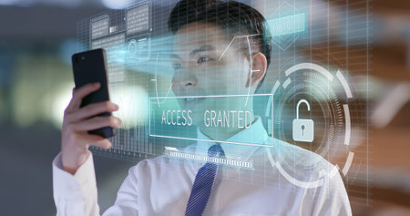 businessman use facial recognition system by smartphone at night in the officeの写真素材