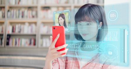 young woman use smart phone unlocking with biometric facial identification indoorの写真素材