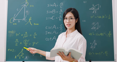 asian senior high school female teacher teach math online through webcam in classroom