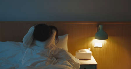 asian woman feel depressed in the bedroom at homeの写真素材