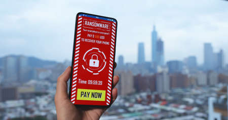 woman read ransomware message on her mobile phone in cityの写真素材