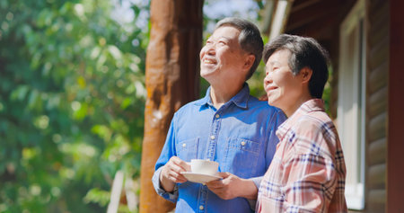 Authentic shot of Asian senior retired man drinking coffee is enjoying travel with his wife and they...