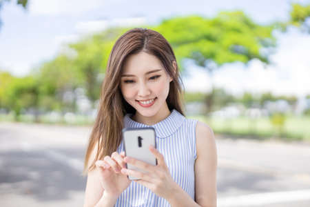 asian businesswoman use phone to search for the information on roadの写真素材