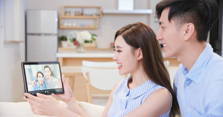 asian young couple have video chat with digital tablet pc at home happily