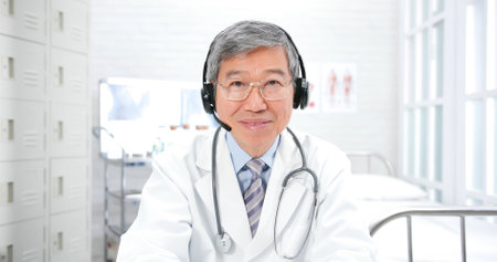 asian senior male doctor look at you in hospitalの写真素材