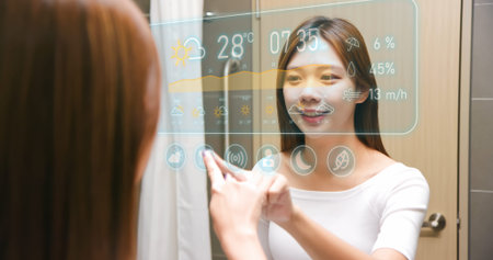 Asian woman looking and touching smart screen at bathroom while waking up-in front of mirror that...