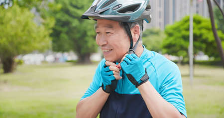 Smiling asian old man wearing helmet-ready to ride the bikeの写真素材