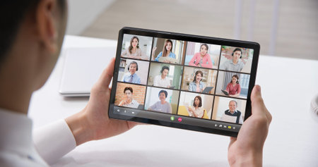 telework concept-rear view of asian businessman has a group video meeting by digital tablet in the...