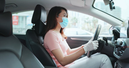 asian successful businesswoman wearing face mask and gloves before she drives car