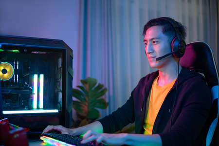 Young Asian Handsome Pro Gamer playing Online Cyber Sport Game at homeの写真素材