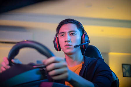Young Asian Pro Gamer Man Play Car Racing Online Video Gameの写真素材