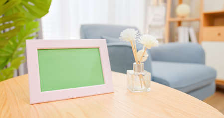 close up of photo frame with green copy space on table in living room at homeの写真素材