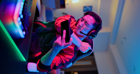 Young asian esport gamer has shoulder pain while playing in Online Video Game on smart phone