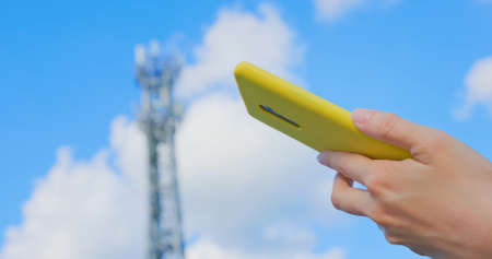 asian woman use smartphone outdoor near 5G base stationの写真素材