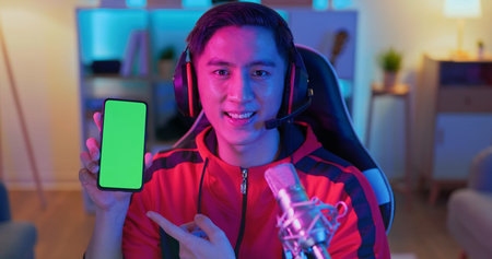 asian man internet celebrity have a live stream and show app on the smartphone with green screen at...