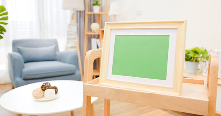 close up of photo frame with green copy space on table in living room at home