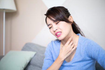 asian woman has dry skin and scratching her neck at homeの写真素材