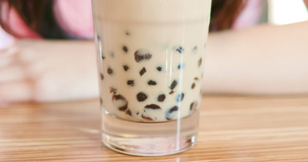 close up of woman drink milk tea with tapioca balls in restaurantの写真素材