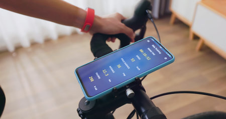 close up of asian woman wearing wearable smart watch ride exercise bike with training information on...
