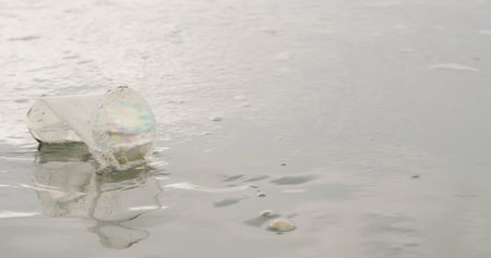 Environmental pollution and disposable plastic cup on beach