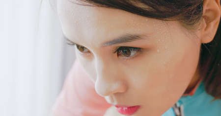 close up of asian woman with sweat on face while doing exerciseの写真素材