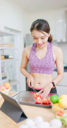 Healthy Lifestyle-asian woman learning how to make healthy cooking by digital tablet and preparing Salad for eatingの写真素材