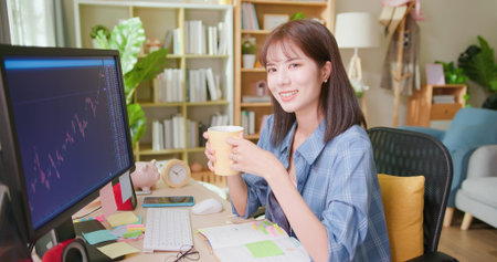 asian woman has stock market or cryptocurrency investment from home by computer and she is relaxed...