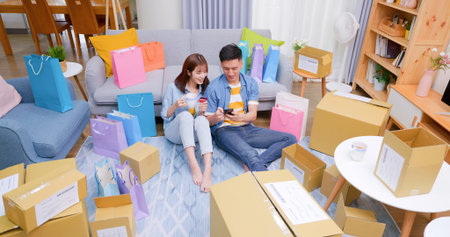high angle view of Happy asian couple shopping online by smartphone with many parcels and woman...