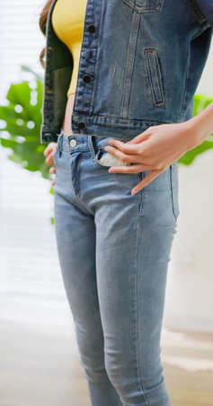 inflation concept - close up of worried asian young female shows her pocket and there has no moneyの写真素材