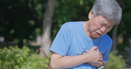 asian elderly man has chest pain or heart disease outside