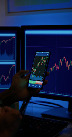 close up of man has stock market or cryptocurrency investment from home by computer with mobile...