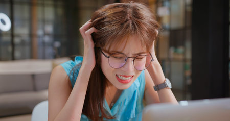 business crisis concept - Stressed Asian woman sitting in office is upset due to work has troubleの写真素材