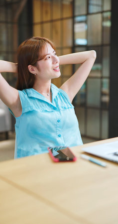 asian businesswoman feels happy after finished her work by mobile phone and laptop computer in...