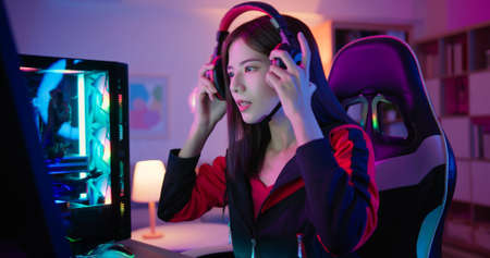 Young Asian Pro Gamer Girl wearing on headset and ready to play Online Video Game at homeの写真素材
