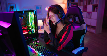 Young asian esport gamer girl feel painful while playing in Online Video Game because her eye is tiredの写真素材