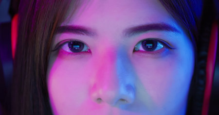 close up of female cyber sport gamer eyes with neon light