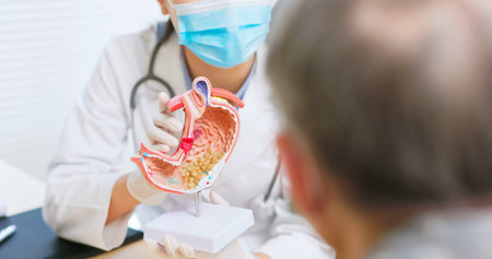 close up of asian female doctor wearing face mask is showing stomach model and explaining to elder...