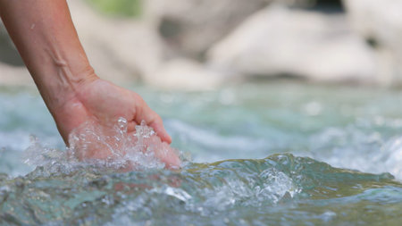 close up of hand touching and holding up water streamsの写真素材