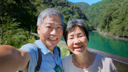 point of view portrait old couple taking selfie video in front the lake and mountain