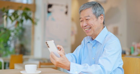 Happy old asian man working in coffee shop have achieved good results
