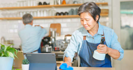 old asian couple cleaning the coffee shopの写真素材