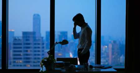 Asian business man being frustrated standing in office hopelesslyの写真素材