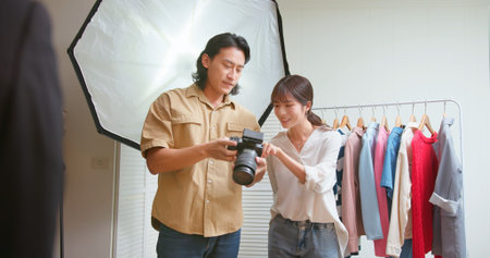 Asian photographer discussing with assistant about result